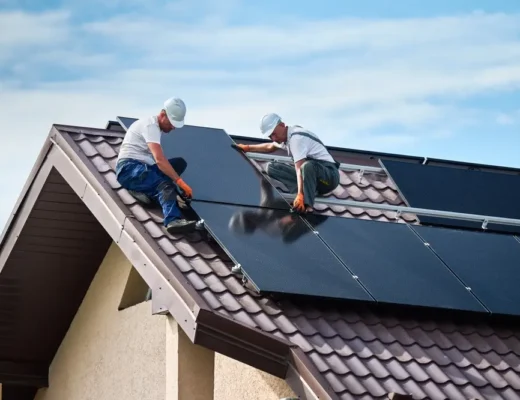 Ouvriers construisant un système de panneaux solaires sur le toit de la maison.